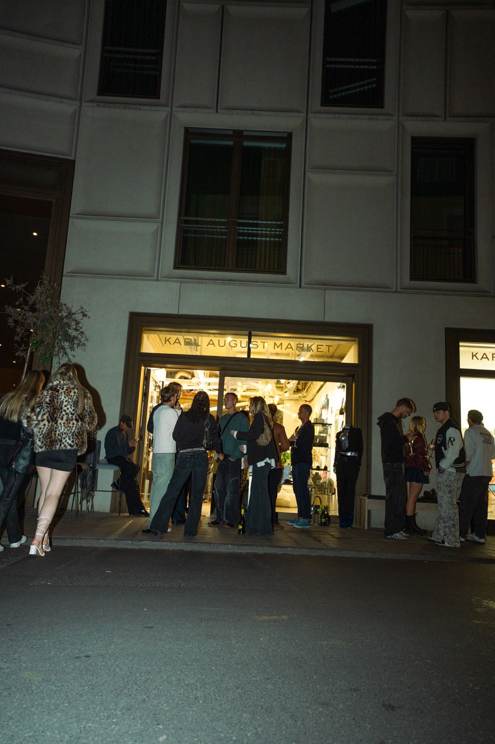 Gäste vor dem beleuchteten Eingang eines Artable Pop-up-Events bei Nacht
